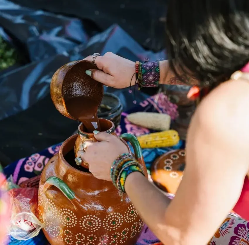 Manos sosteniendo una taza de cacao ceremonial